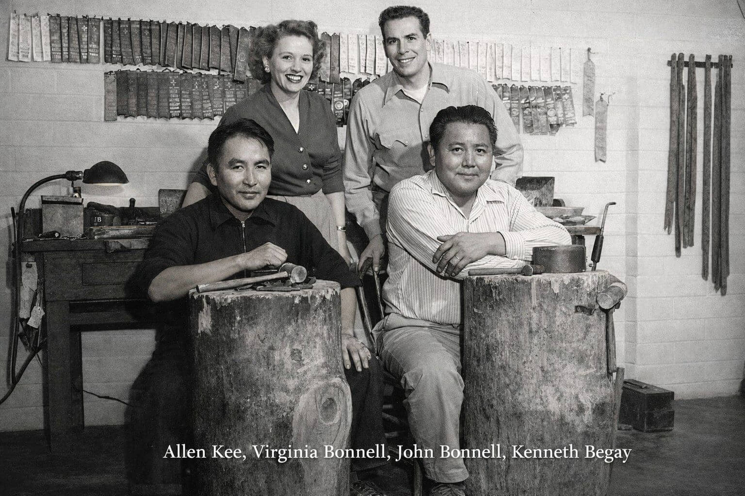 Four people in a workshop, black and white.