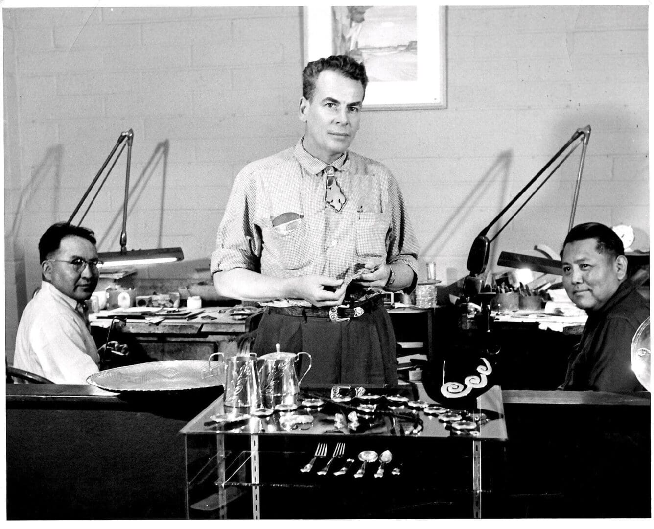 Three men in a jewelry workshop.