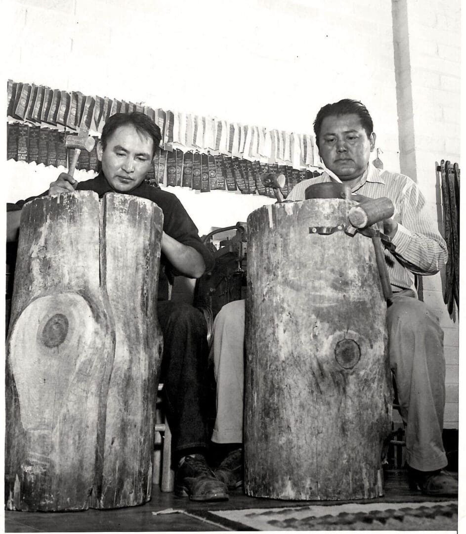 Two men playing traditional log drums.