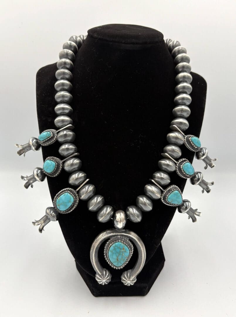 Silver and turquoise beaded necklace on display.