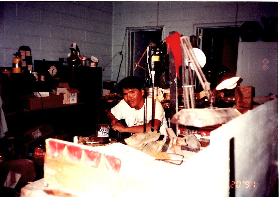 Man working in cluttered workshop.