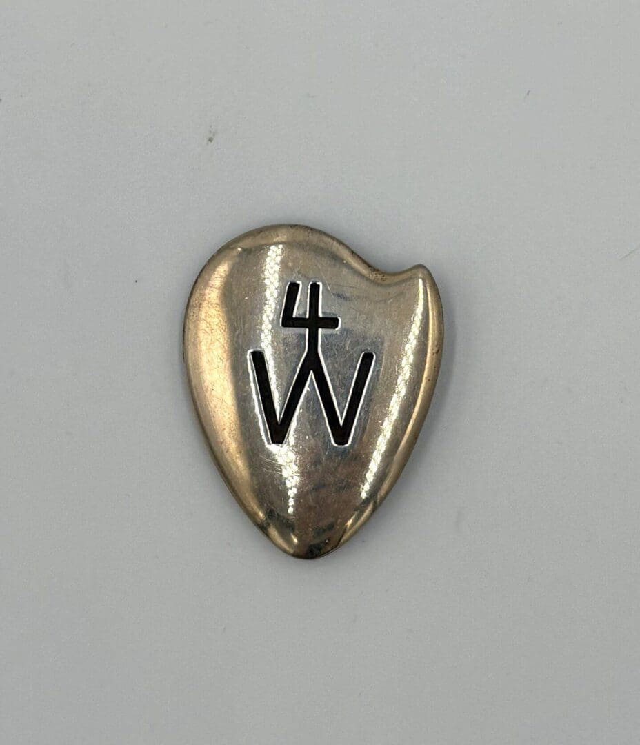Metal heart-shaped object with engraved symbols.
