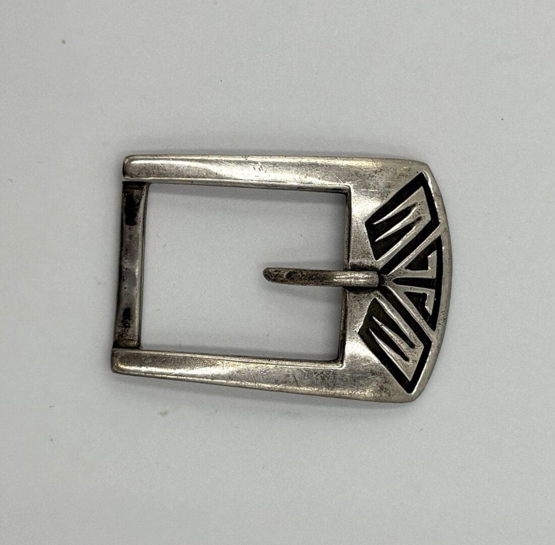 Silver belt buckle with geometric design.
