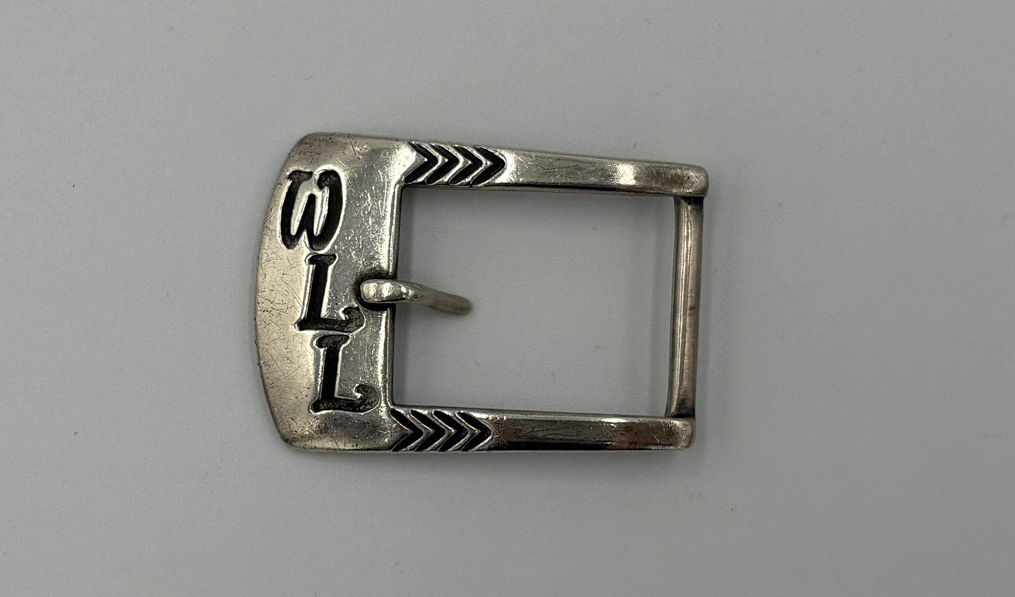Silver belt buckle with engraved design.