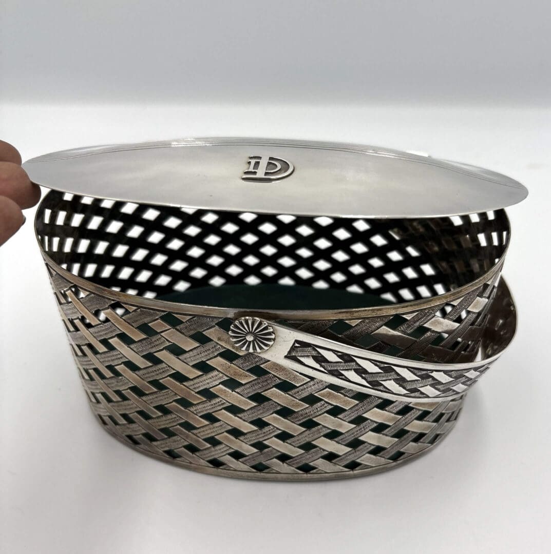 Silver woven basket with a lid.