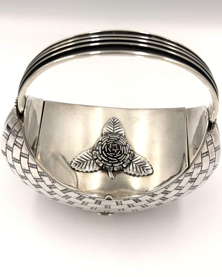 Silver basket with floral design and handle.