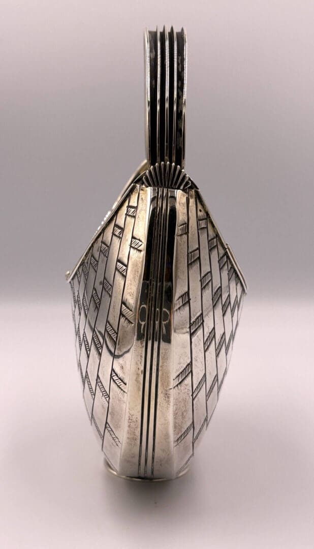 Silver teapot with intricate geometric design.