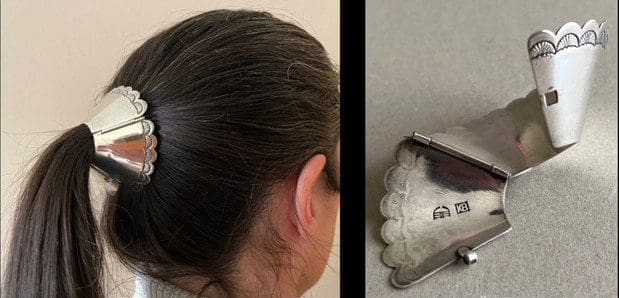 Silver hair accessory with scalloped design.