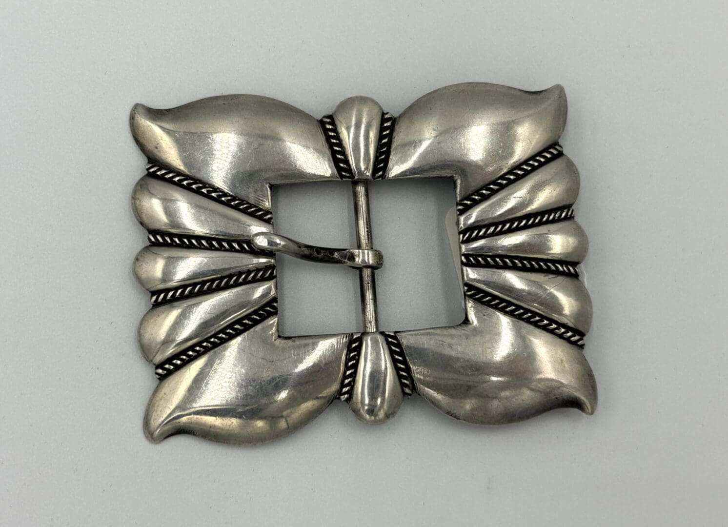 Ornate silver buckle with leaf design.