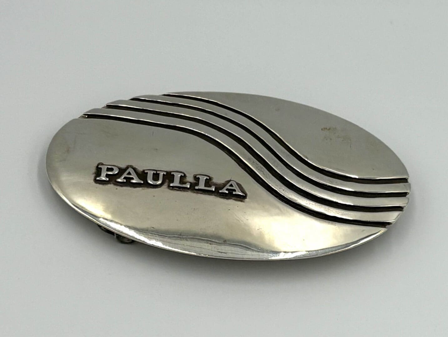 Oval silver badge with "PAULLA" text.