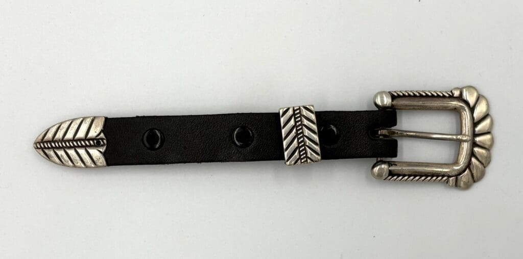 Black leather belt with decorative silver buckle.
