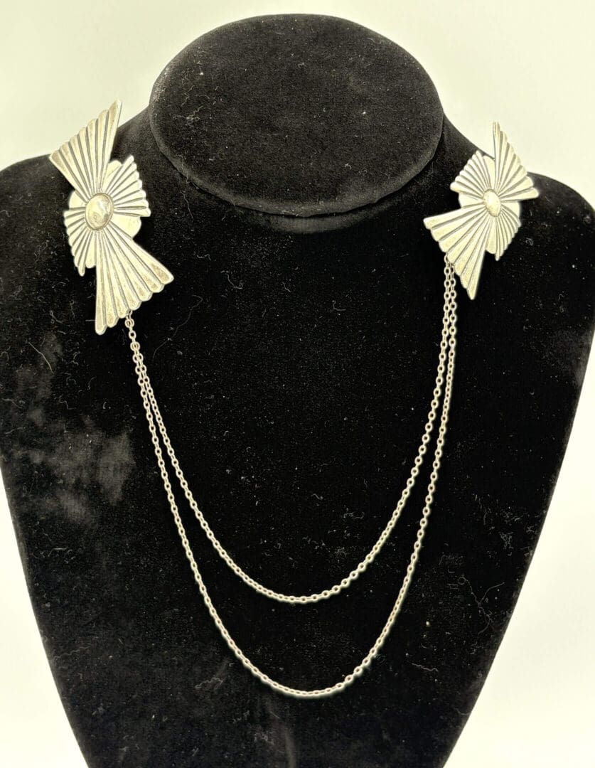Silver chain brooch with geometric designs.