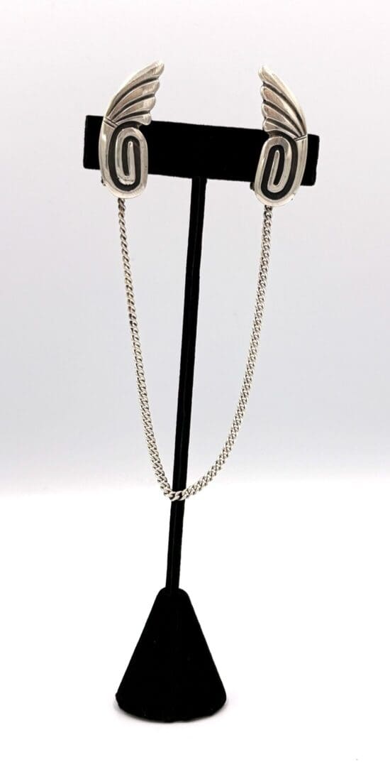 Silver winged brooch with connecting chain.