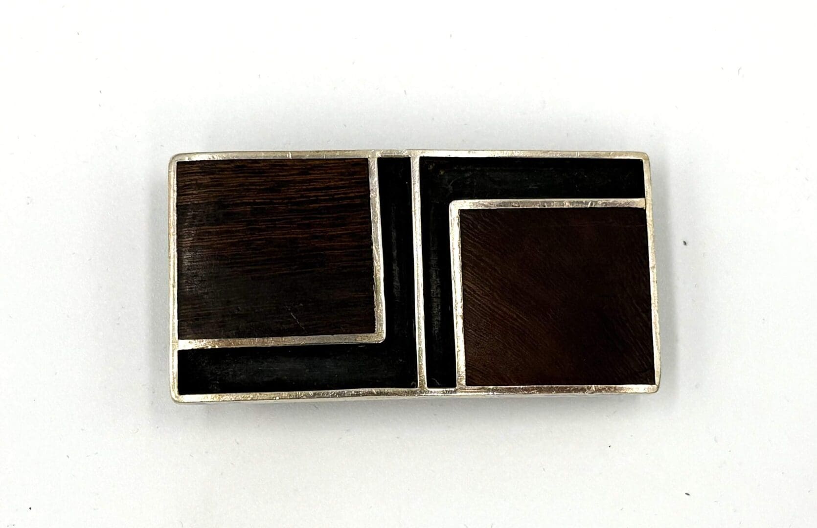 Rectangular geometric brooch with dark panels.