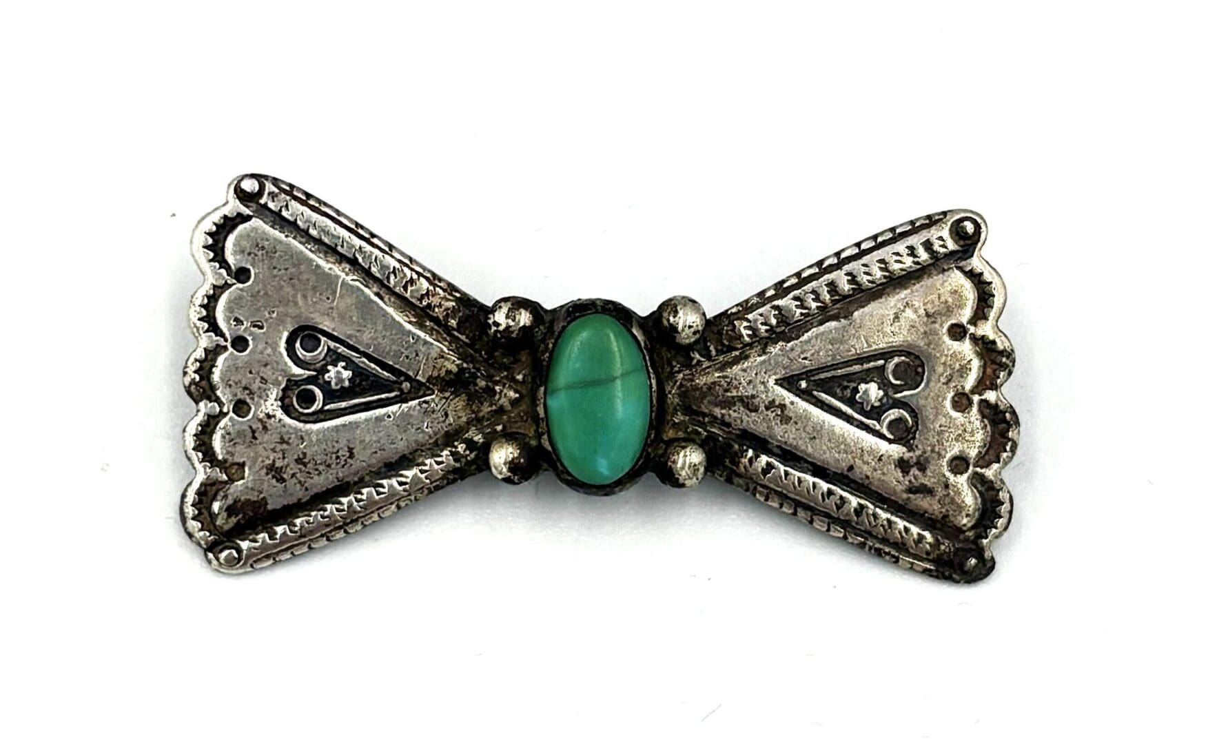 Silver brooch with turquoise stone centerpiece.