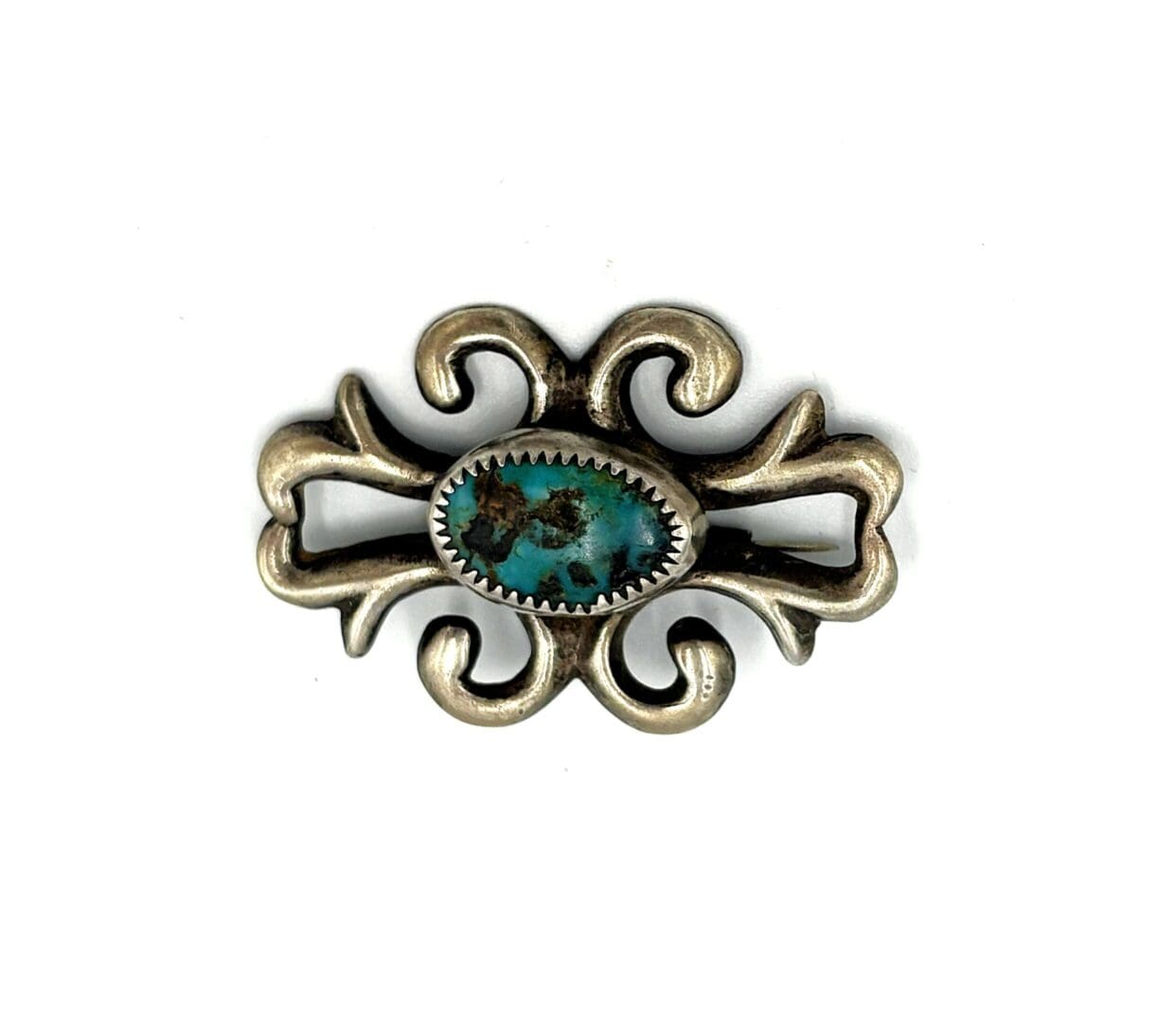 Ornate silver brooch with turquoise stone.