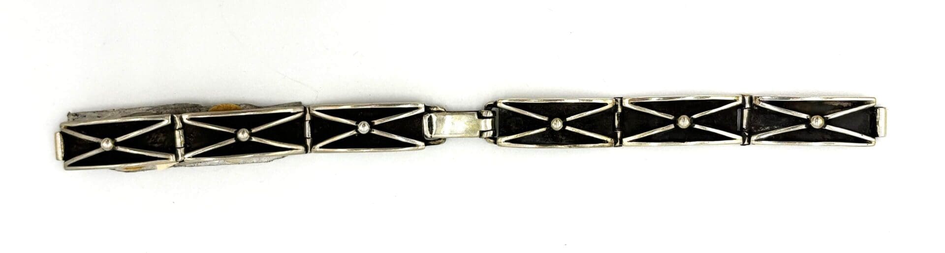 Geometric black and silver bracelet on white background.