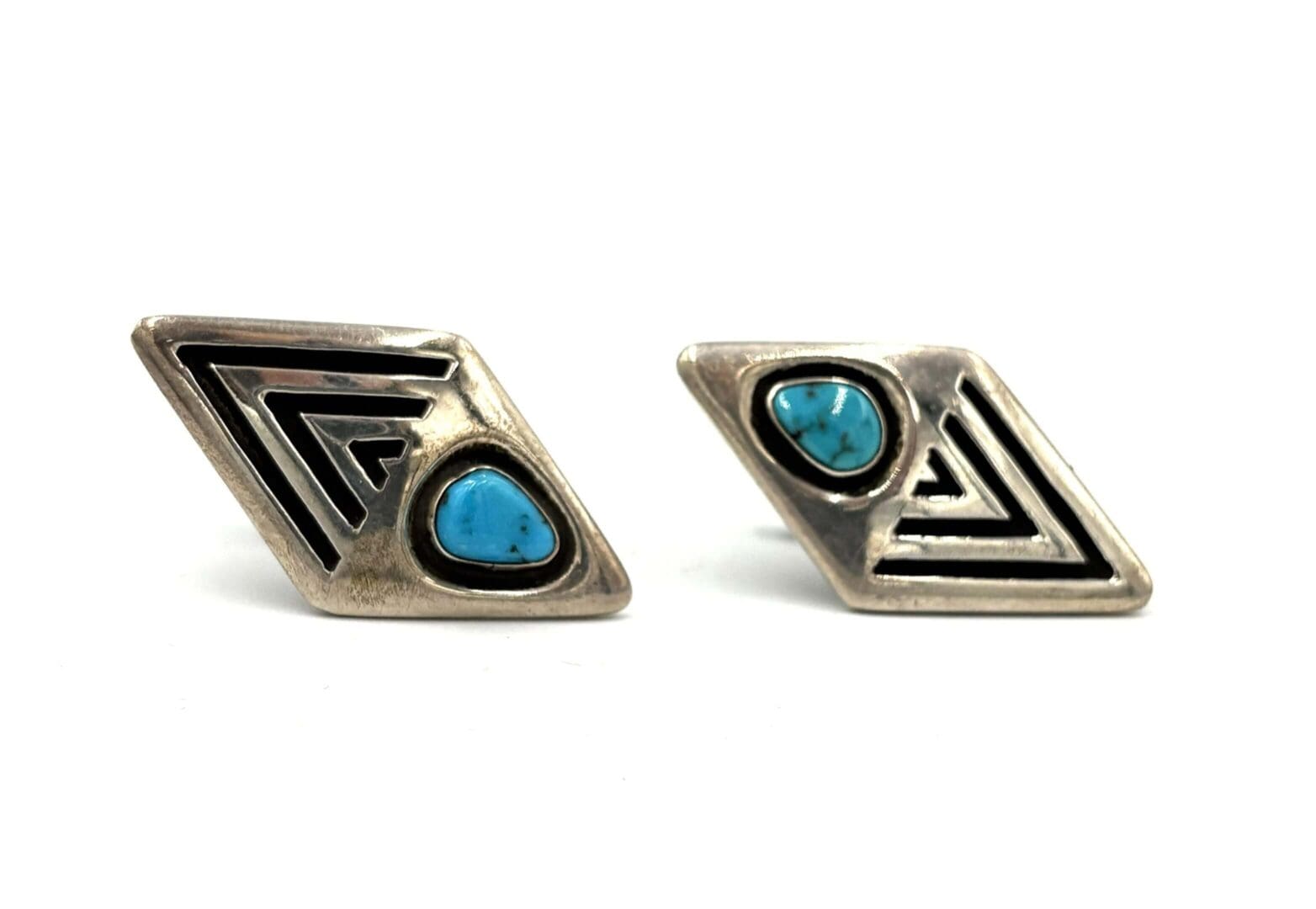 Geometric silver earrings with turquoise stones.
