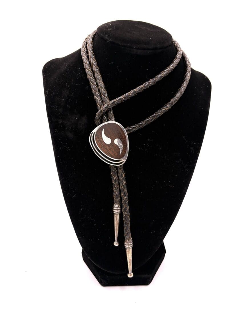 Braided bolo tie with decorative metal tips.
