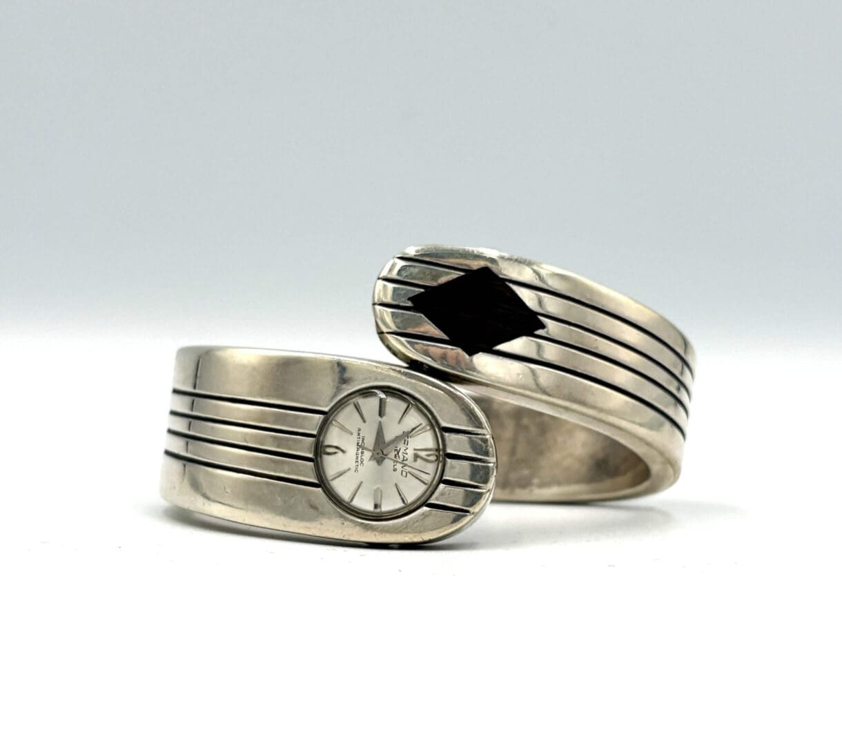 Silver watch and bracelet with striped design.