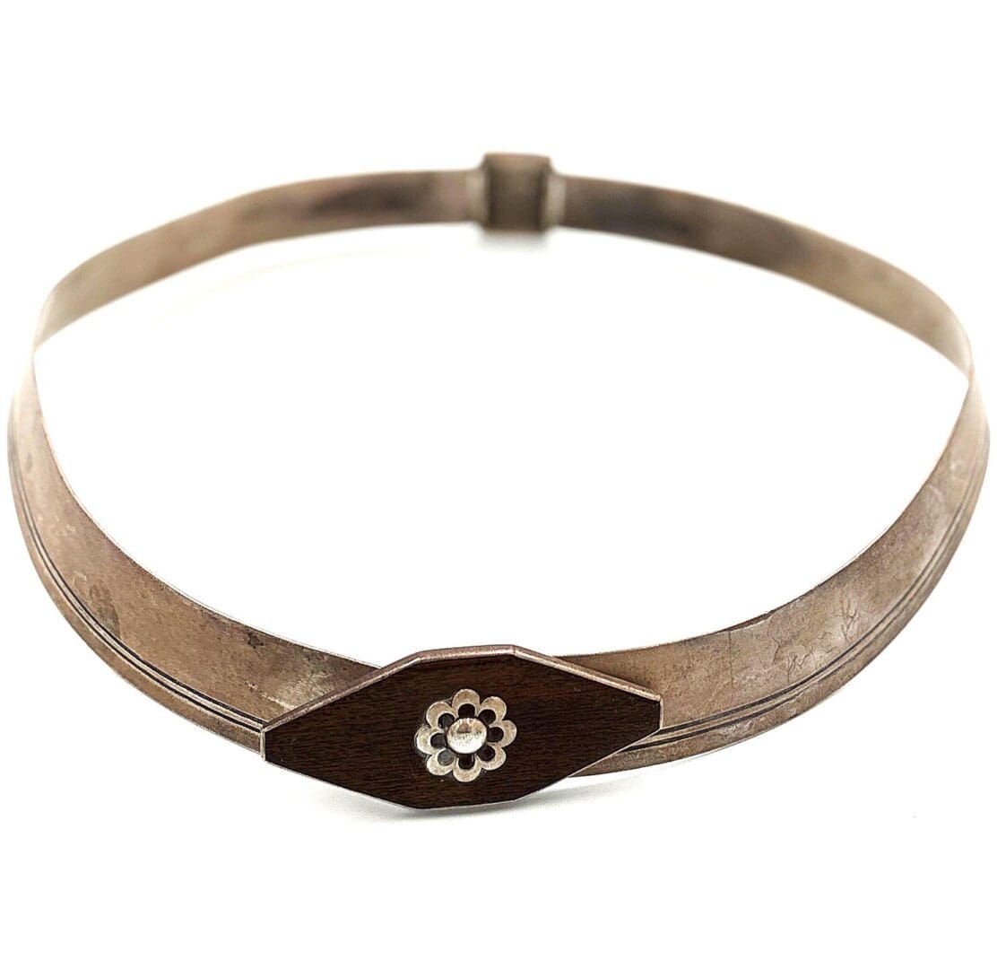 Silver choker necklace with floral clasp.