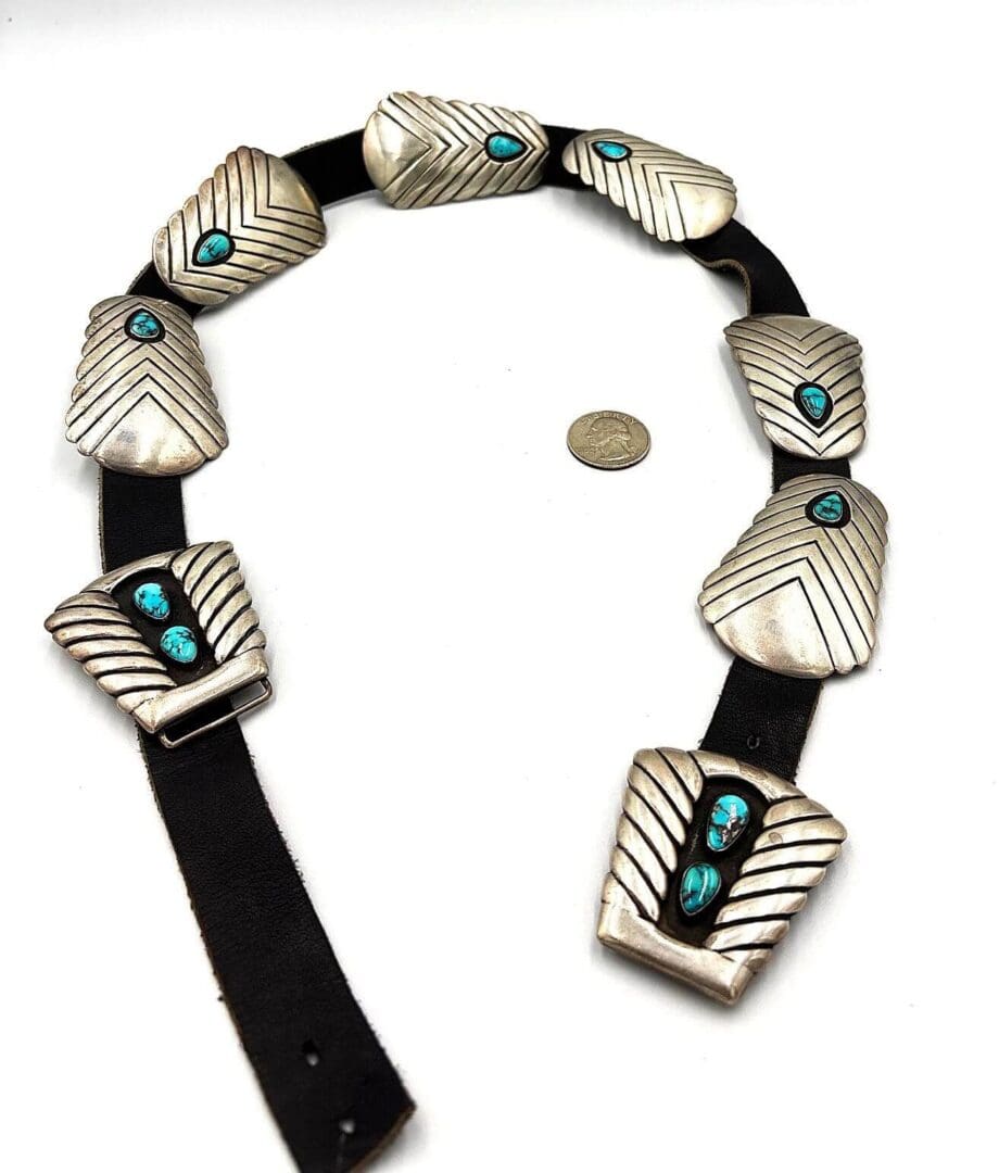 Silver belt with turquoise stones and coin.