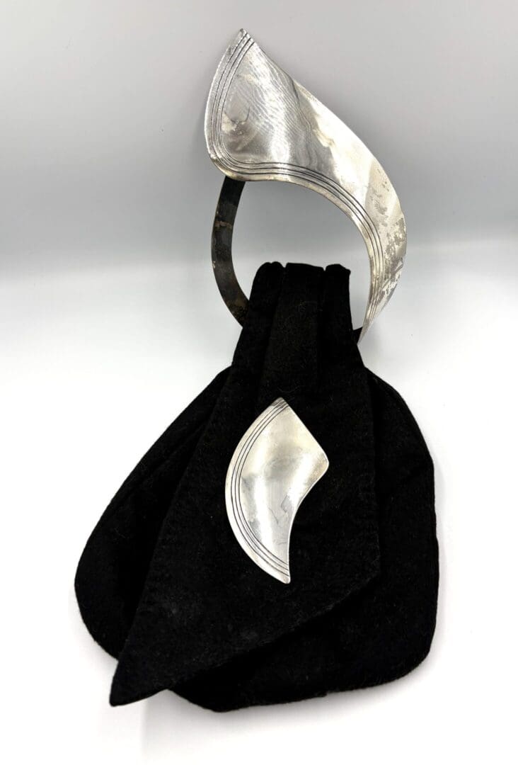 Silver and black abstract sculpture with curves.