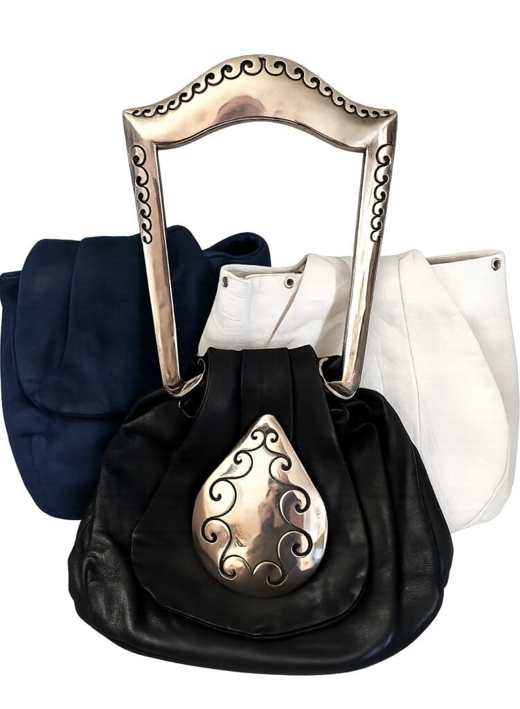 Three stylish handbags with unique handles.
