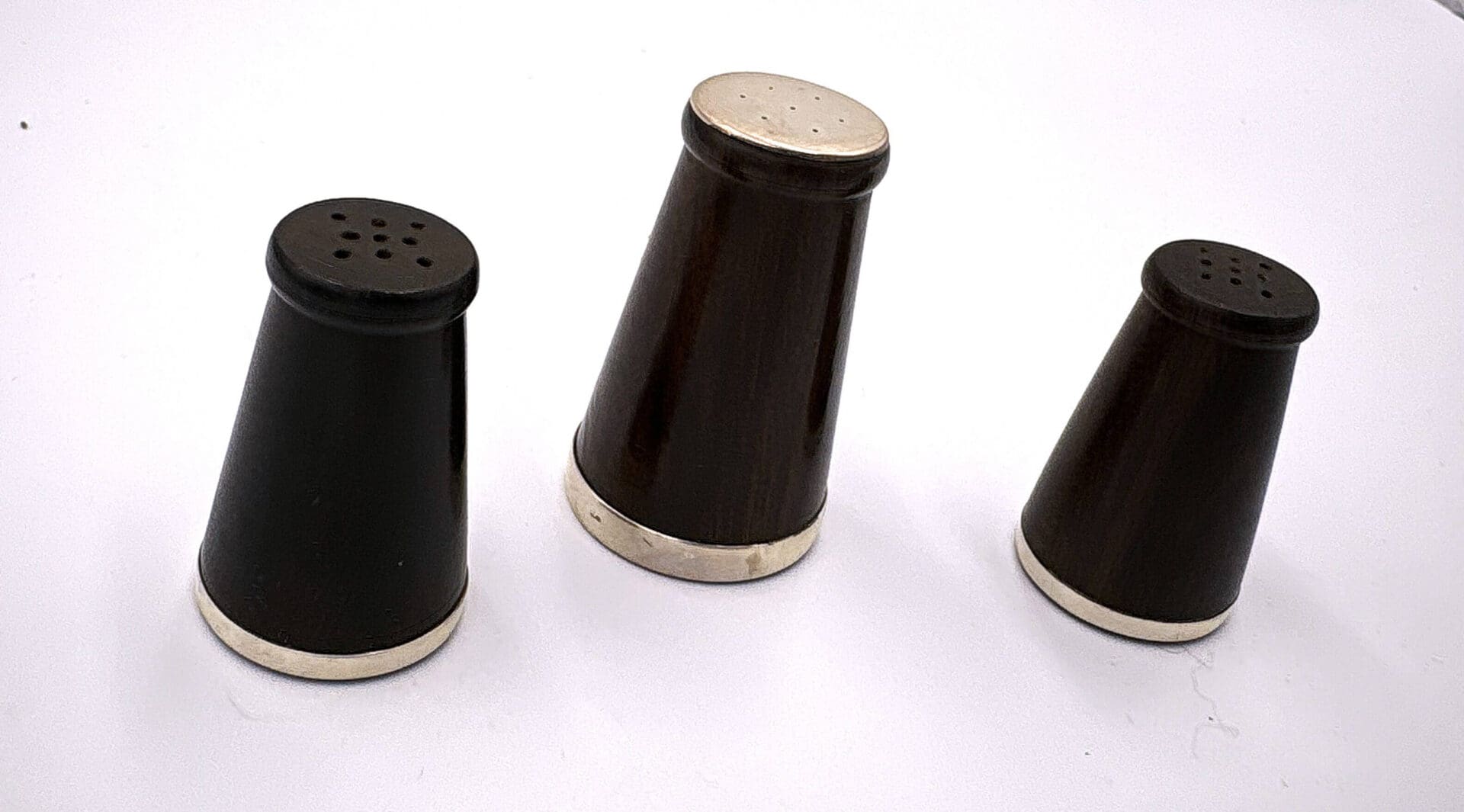 Three black salt and pepper shakers.