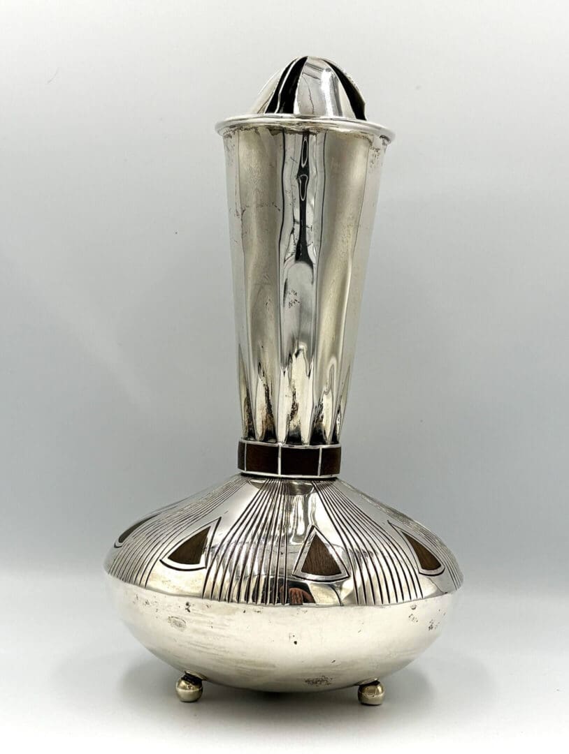 Silver decorative vase with geometric patterns.