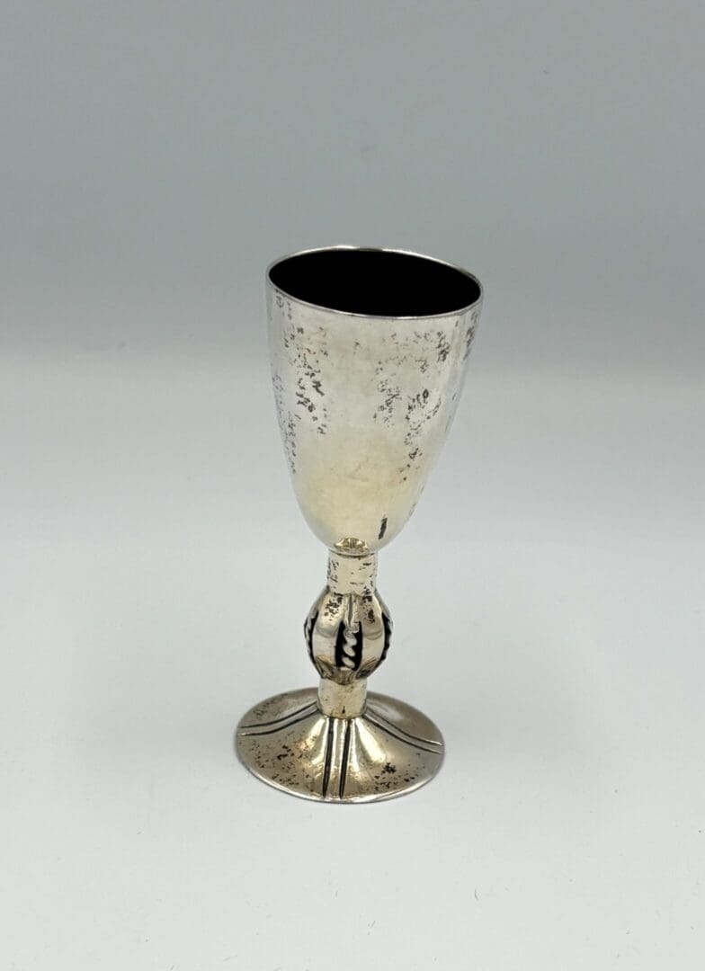 Silver goblet with ornate stem design.