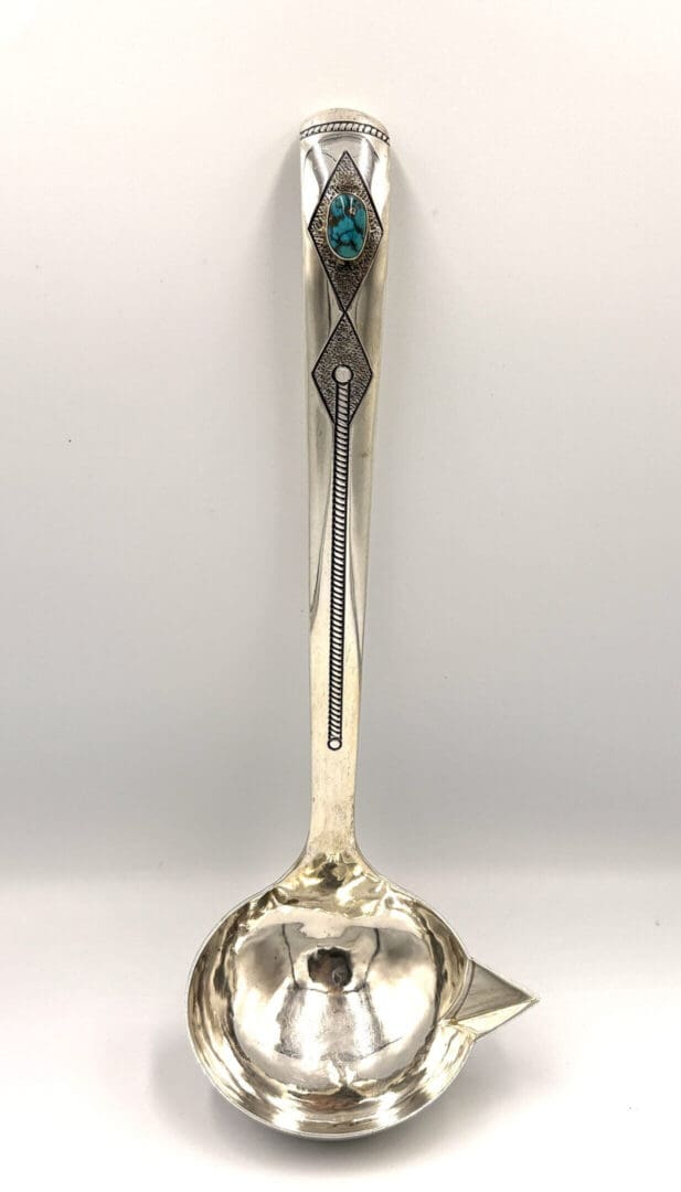 Silver ladle with turquoise and geometric designs.