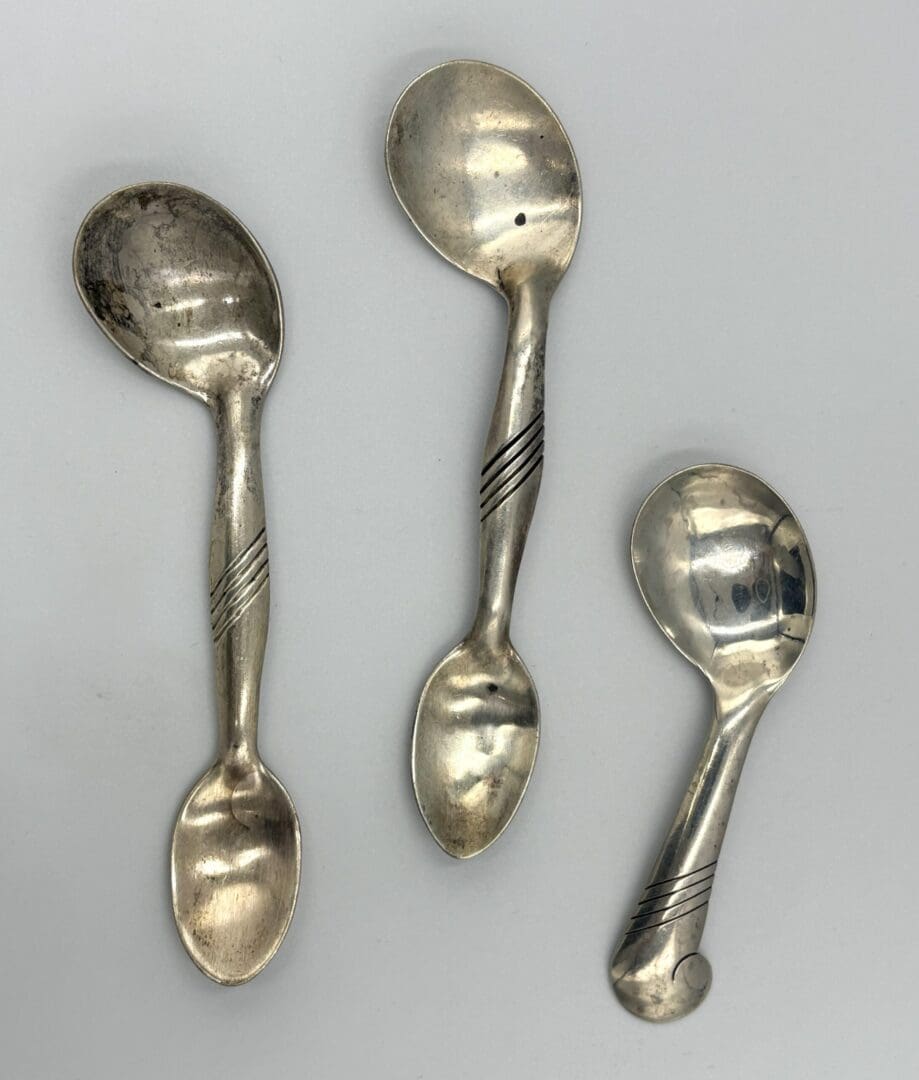 Three vintage silver spoons with spiral design.