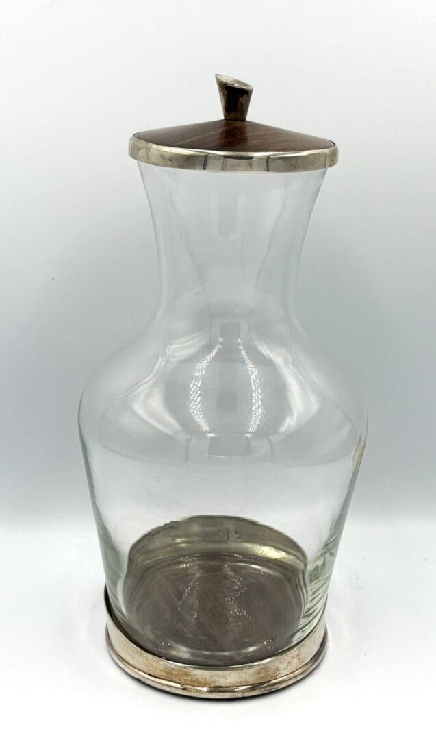 Glass jar with metal lid and base.