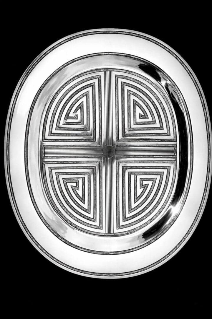 Ornate silver oval tray with geometric pattern.