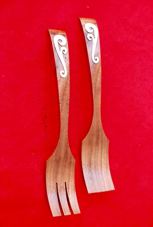 Wooden utensils with decorative handles on red.