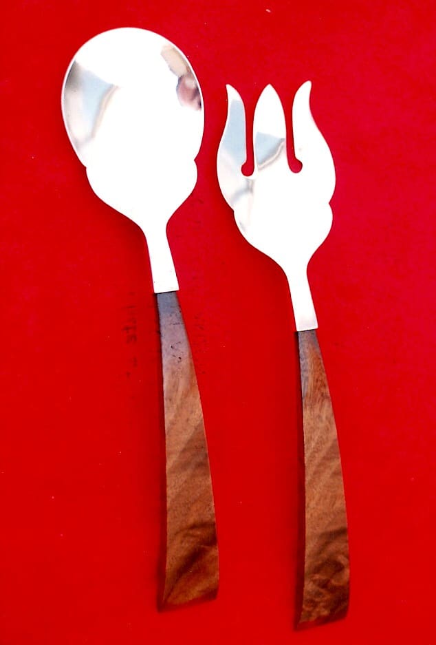Wood-handled spoon and fork on red background.