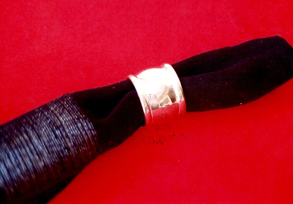 Black napkin with silver ring on red.