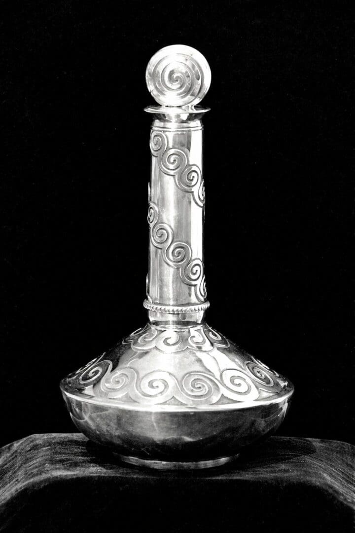 Ornate silver vase with swirling patterns.