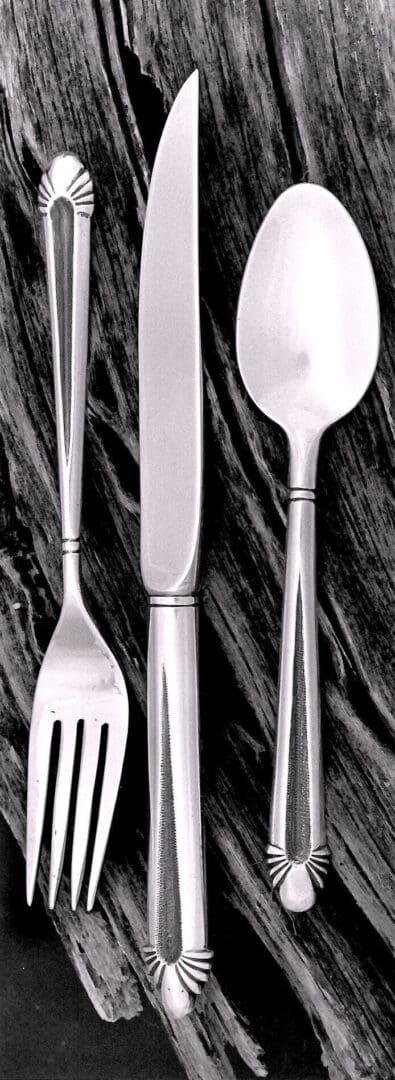 Silver cutlery set on wooden background.