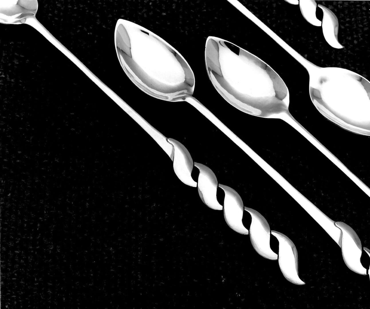 Twisted-handle spoons on black background.