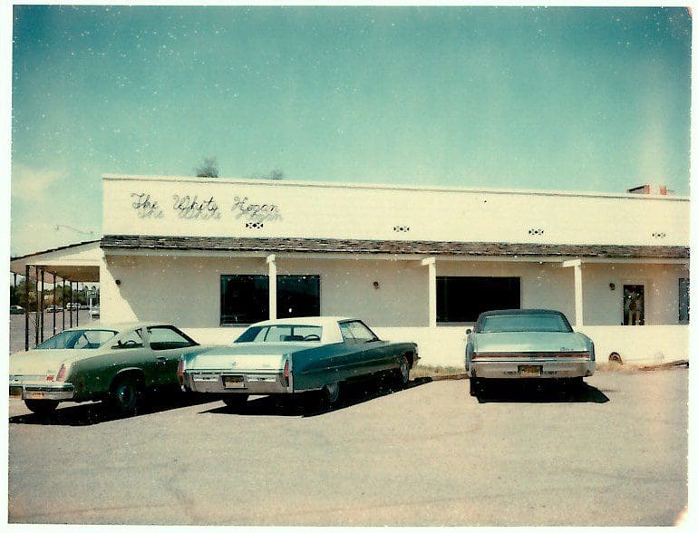 Vintage cars parked outside a white building.