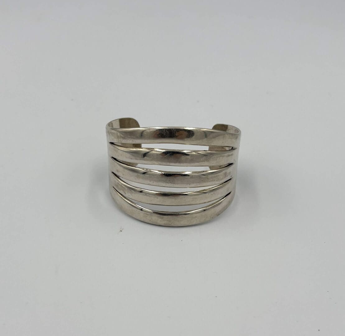 Silver cuff bracelet with cutout design.