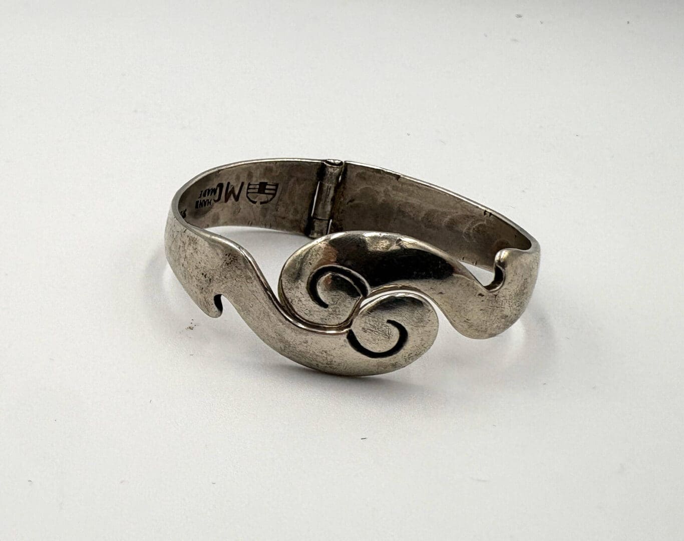 Silver bracelet with abstract swirl design.
