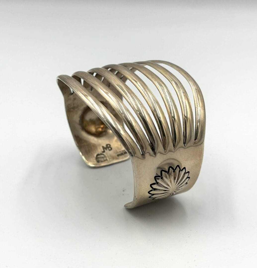 Silver cuff bracelet with cutout design.