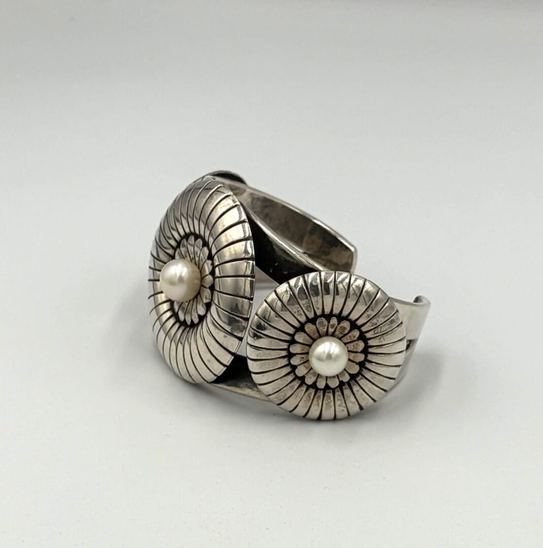 Silver bracelet with pearl accents, floral design.