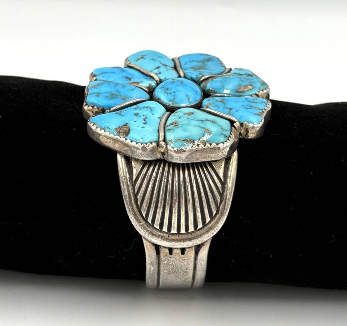 Silver bracelet with turquoise flower design.