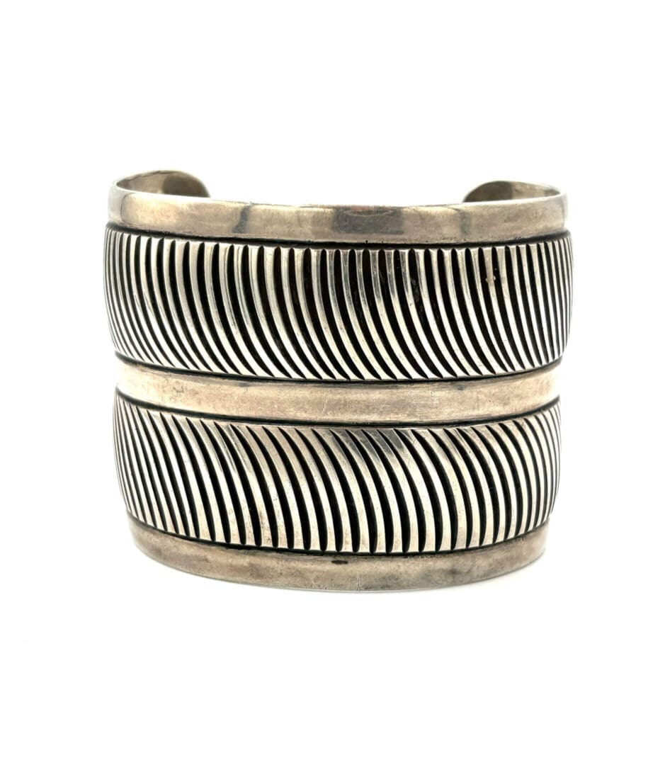 Silver cuff bracelet with striped pattern.