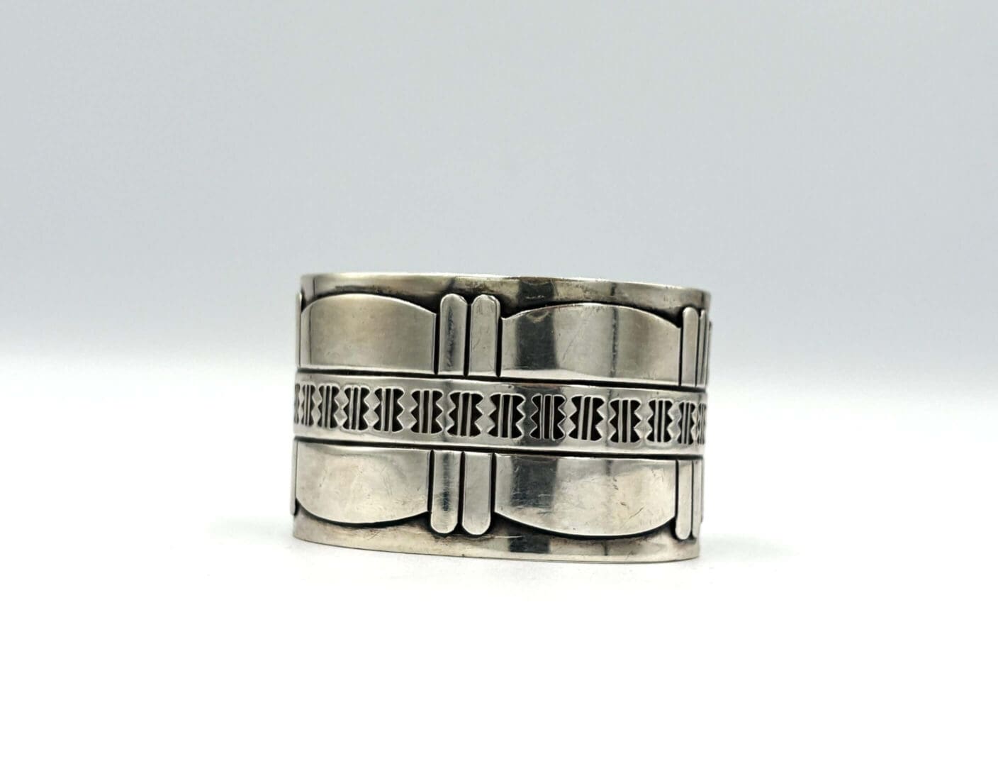 Silver cuff bracelet with engraved geometric patterns.