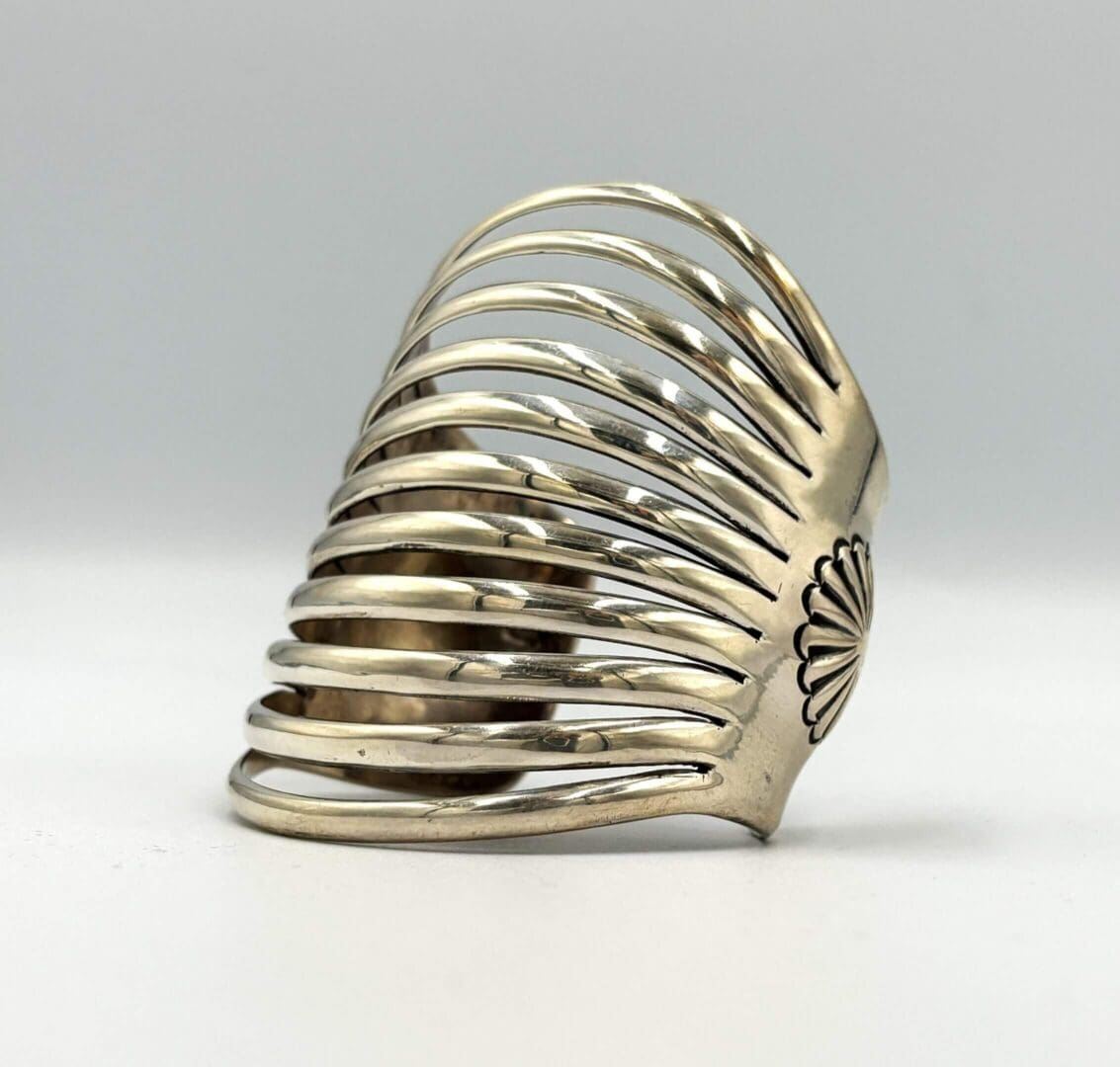 Silver ring with intricate cutout design.